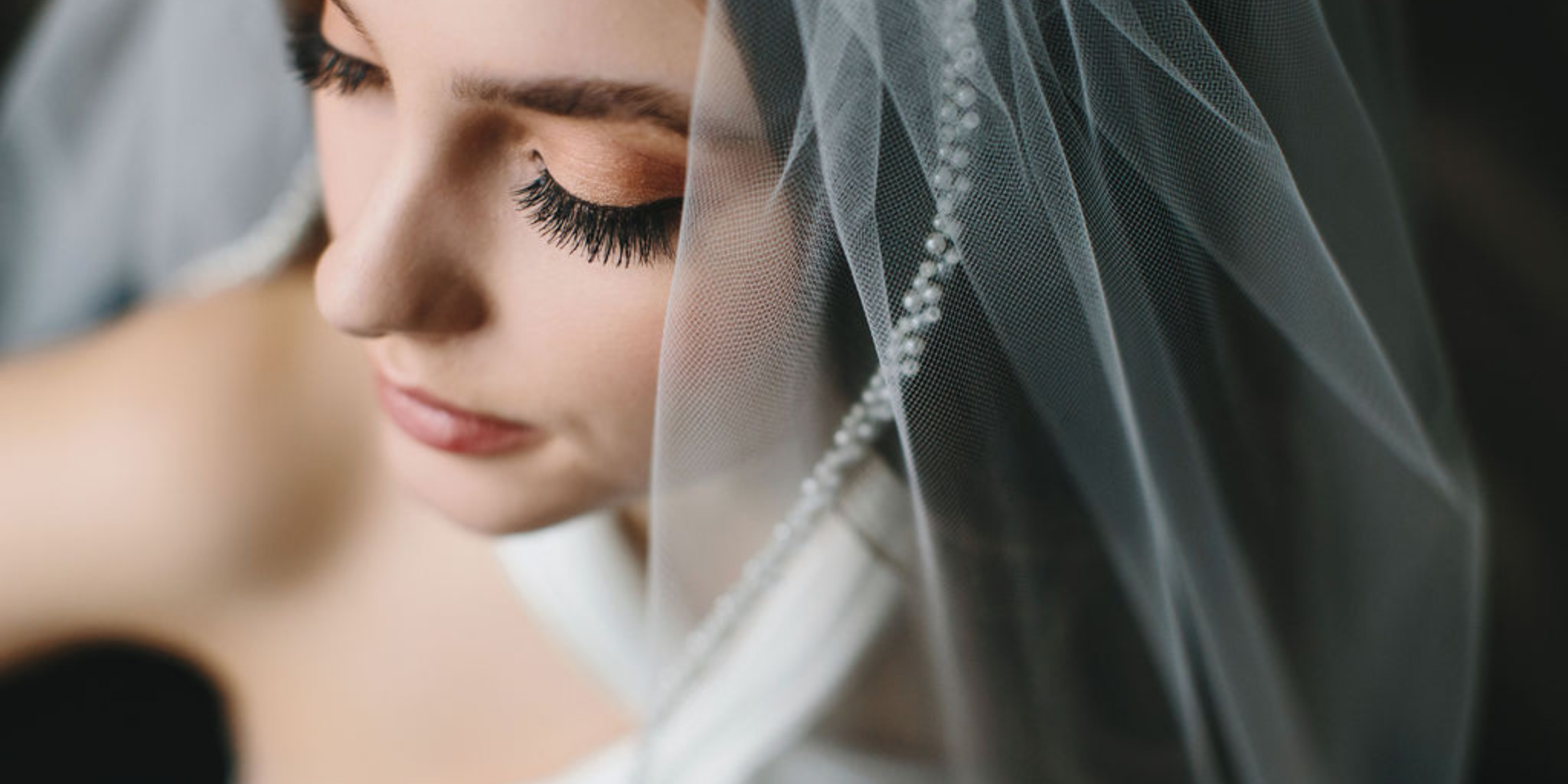 Bride wearing veil with pearls ivory color on her wedding day