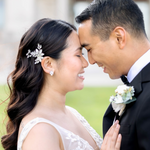 Bride wearing earrings and floral hair pin on her wedding day with groom