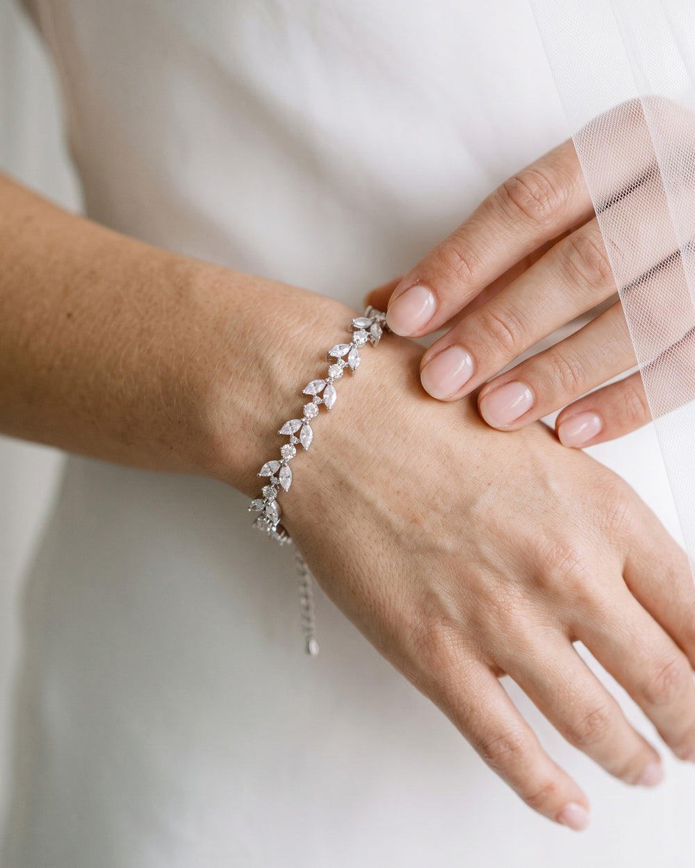 Bride in a white dress wearing the Sydney CZ wedding bracelet with floral cubic zirconia links
