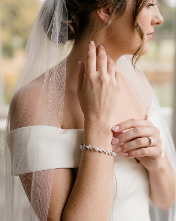 Bride in a veil and off-shoulder dress wearing the Kelsey pearl and cubic zirconia bracelet
