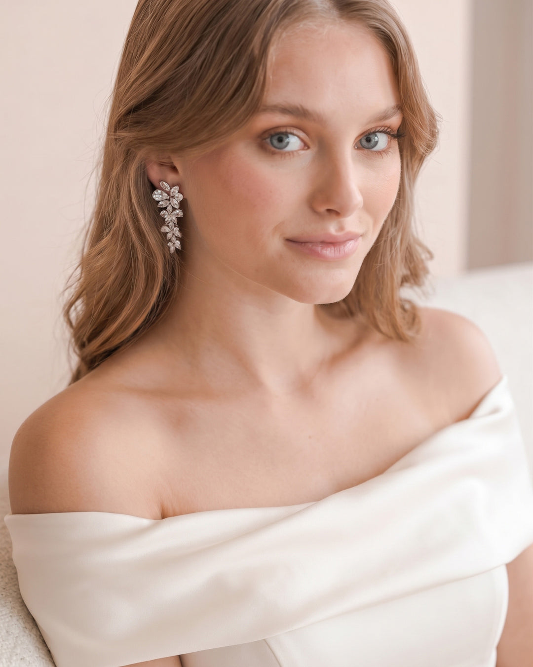 Model in an off-the-shoulder gown wearing the Delilah cubic zirconia wedding earrings