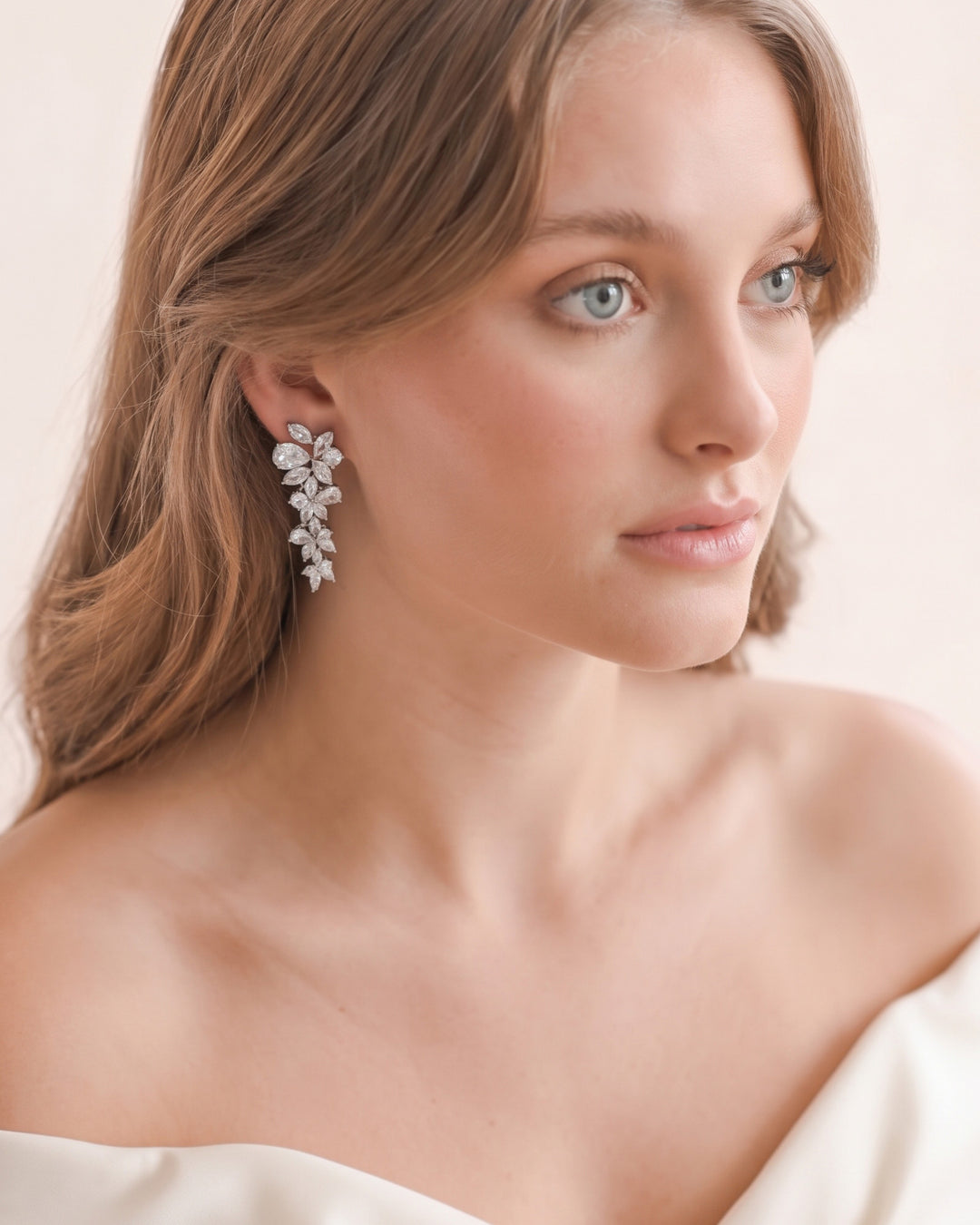 Close look at a Delilah earring on the ear as the bride turns her head away
