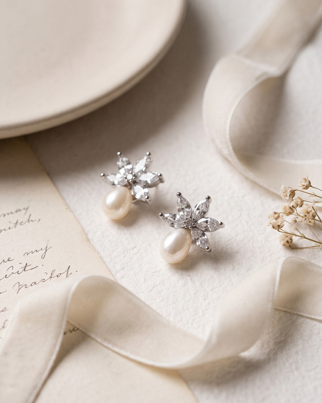 Pair of Naomi earrings showing marquise CZ above luminous freshwater pearls