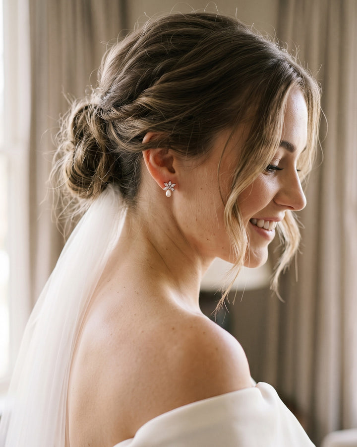 Bride with a low updo and veil wearing the Naomi freshwater pearl wedding studs