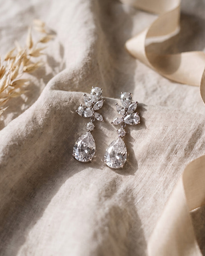 Silver Madison earrings on soft linen showing the floral cluster above each pear drop