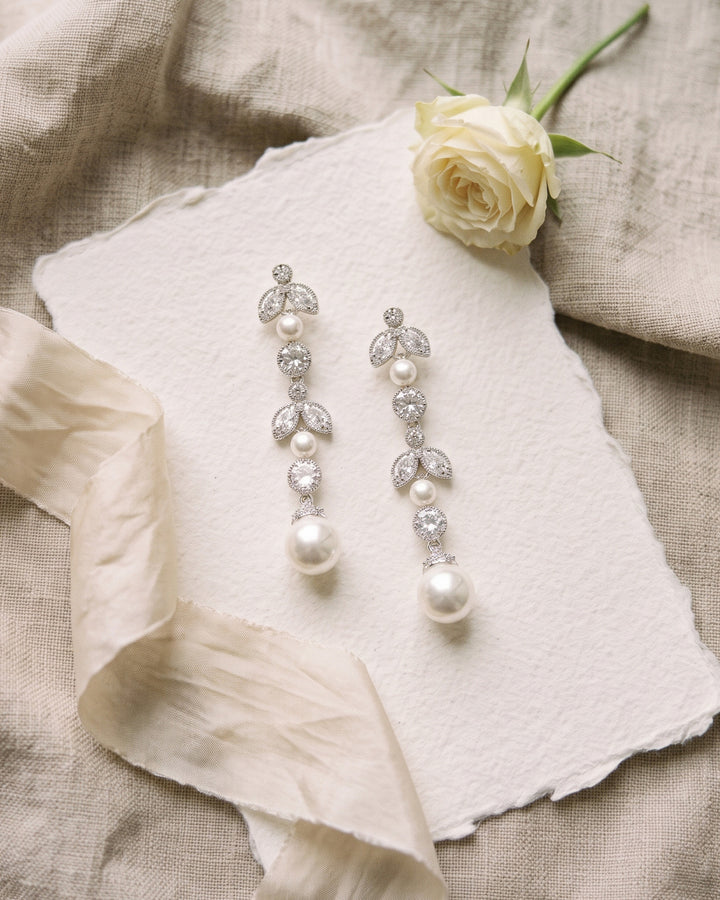 Sabrina pearl drop earrings on handmade paper with ivory ribbon and a white rose