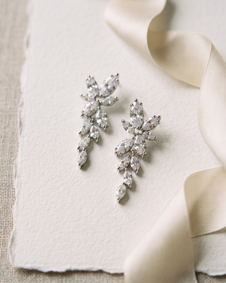 Nicole silver bridal drop earrings with cascading marquise cubic zirconia leaves on cream paper