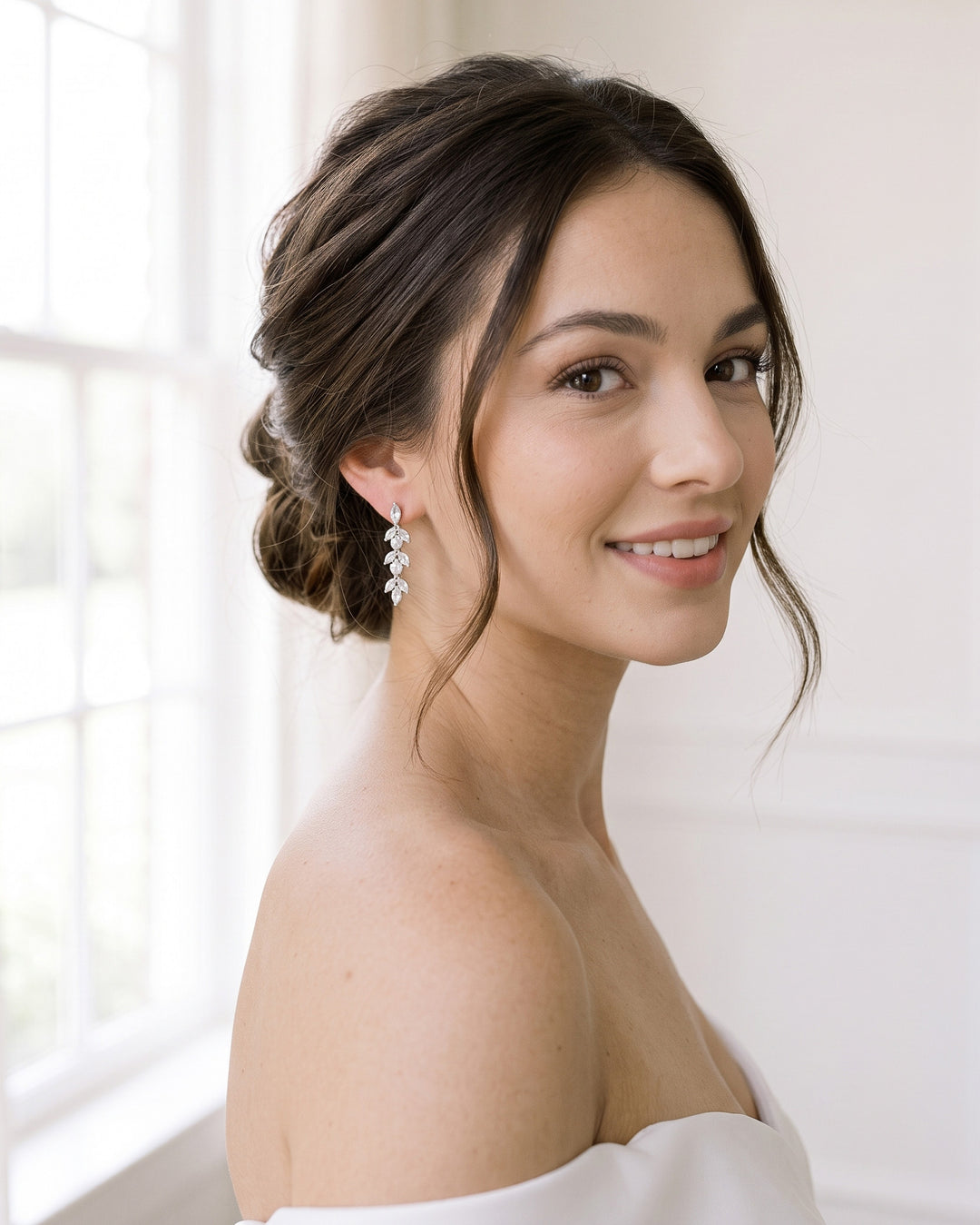 Bride in an off-the-shoulder gown wearing the Sydney Pearl earrings with a romantic low bun