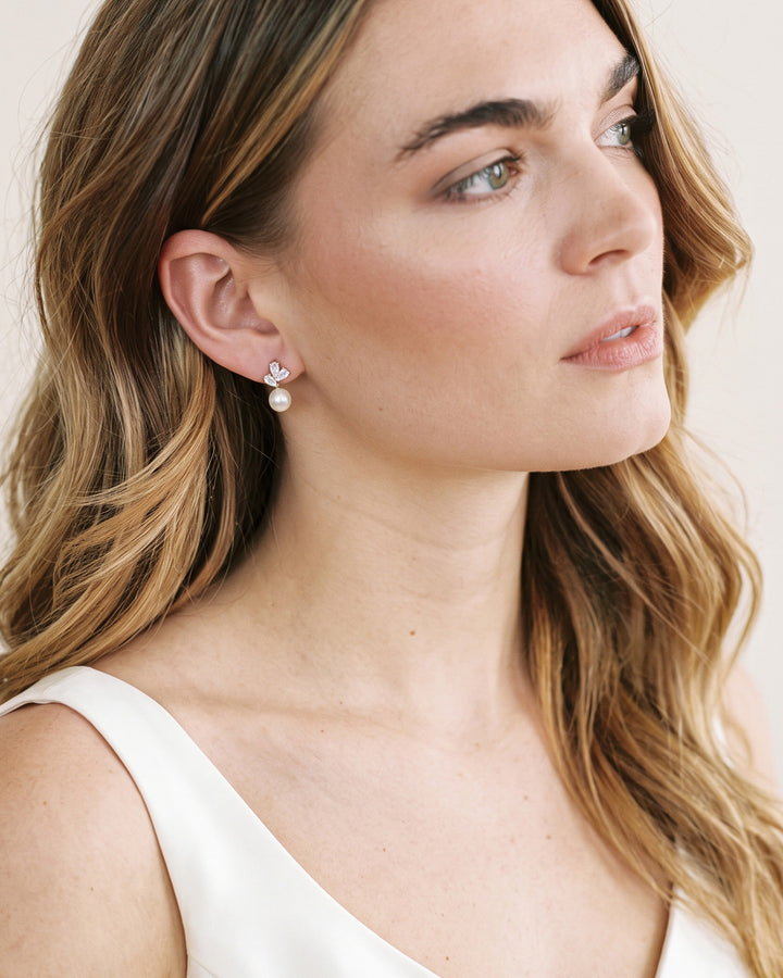 Profile of a bride with long waves wearing Meadow CZ and pearl bridal studs