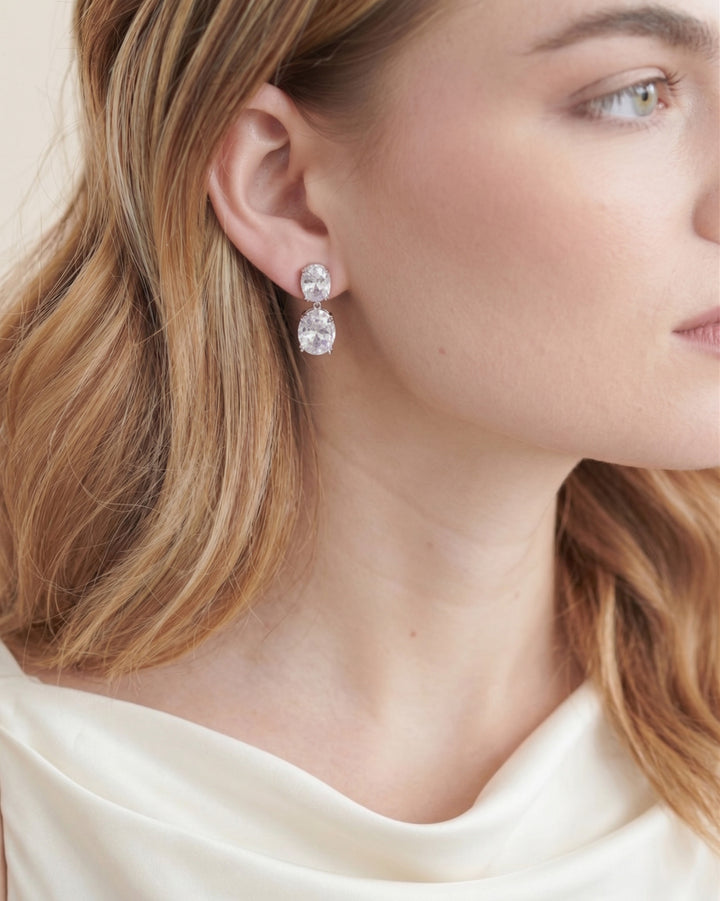 Close-up of a bride in a cowl-neck gown wearing the Rosina oval CZ drop earrings