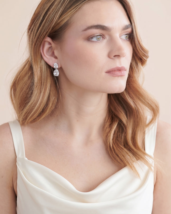 Bride with soft strawberry blonde waves wearing silver Rosina wedding earrings
