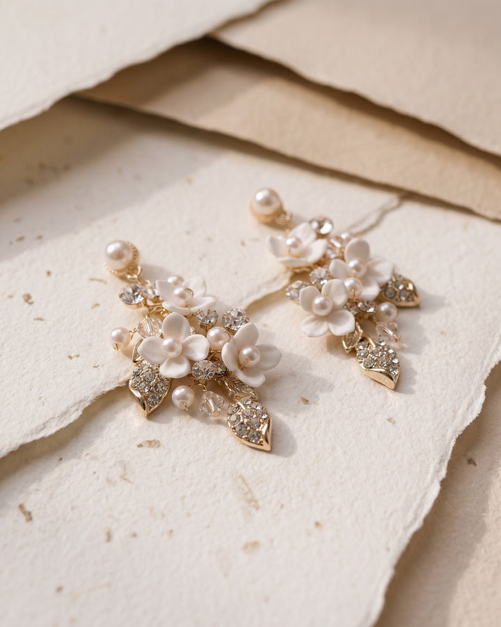 Gold Lani earrings on handmade paper, showing pearl-centered blossoms and crystal leaves