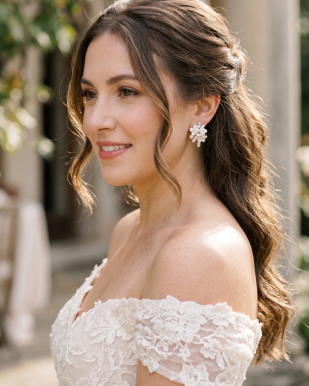 Bride with long half-up waves wearing the Elin floral cluster stud earrings in a lace gown