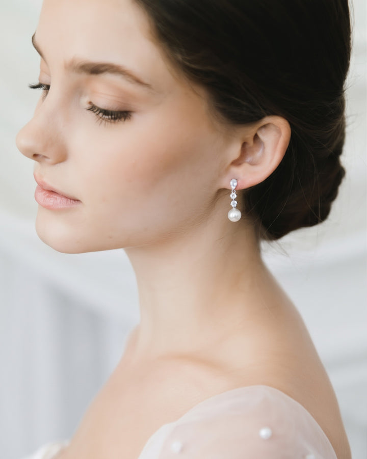 Bride with a low bun wearing Bailey pearl drop earrings with cubic zirconia, side profile