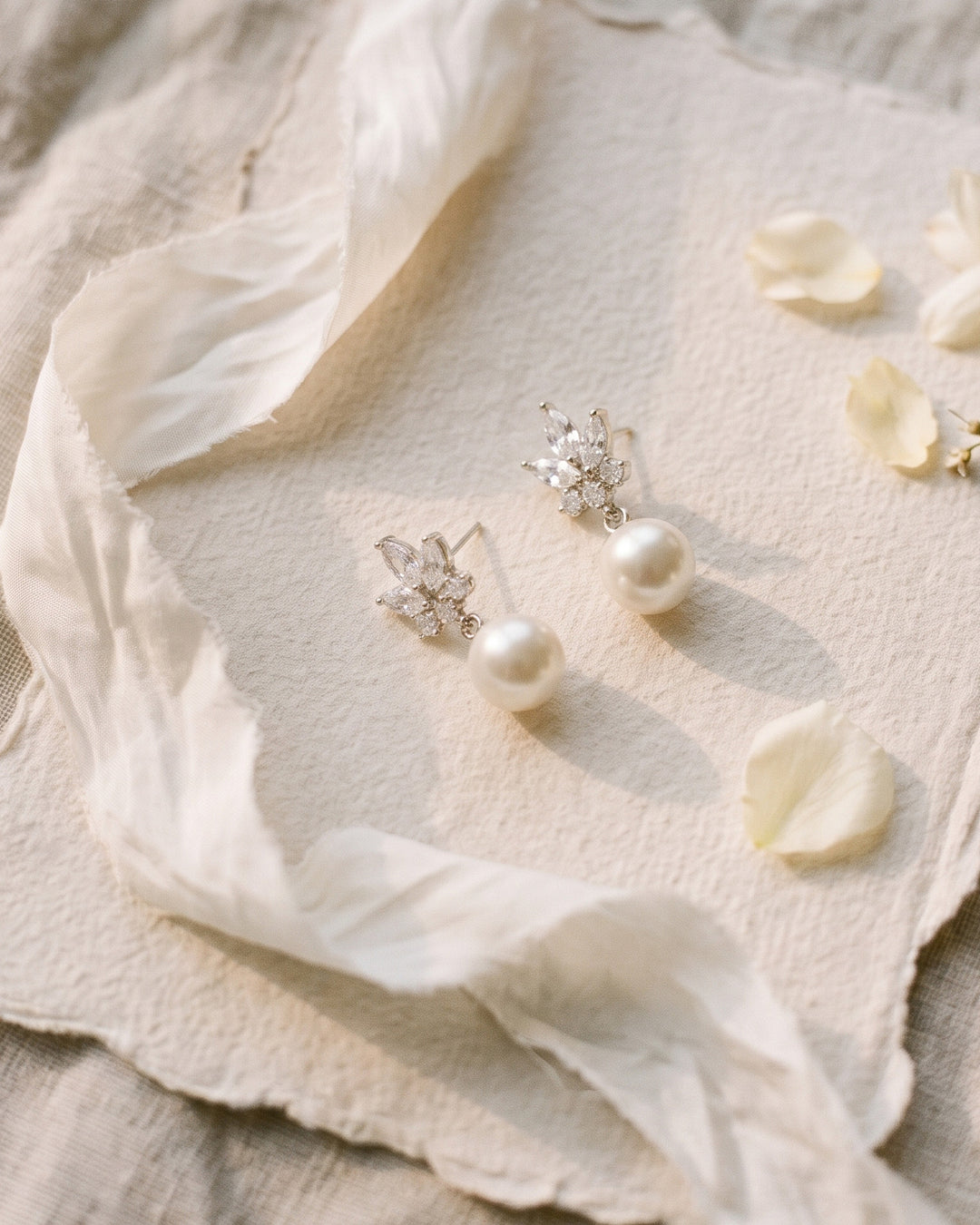 Peyton silver bridal pearl drop earrings with marquise cubic zirconia florals, styled with ivory silk ribbon
