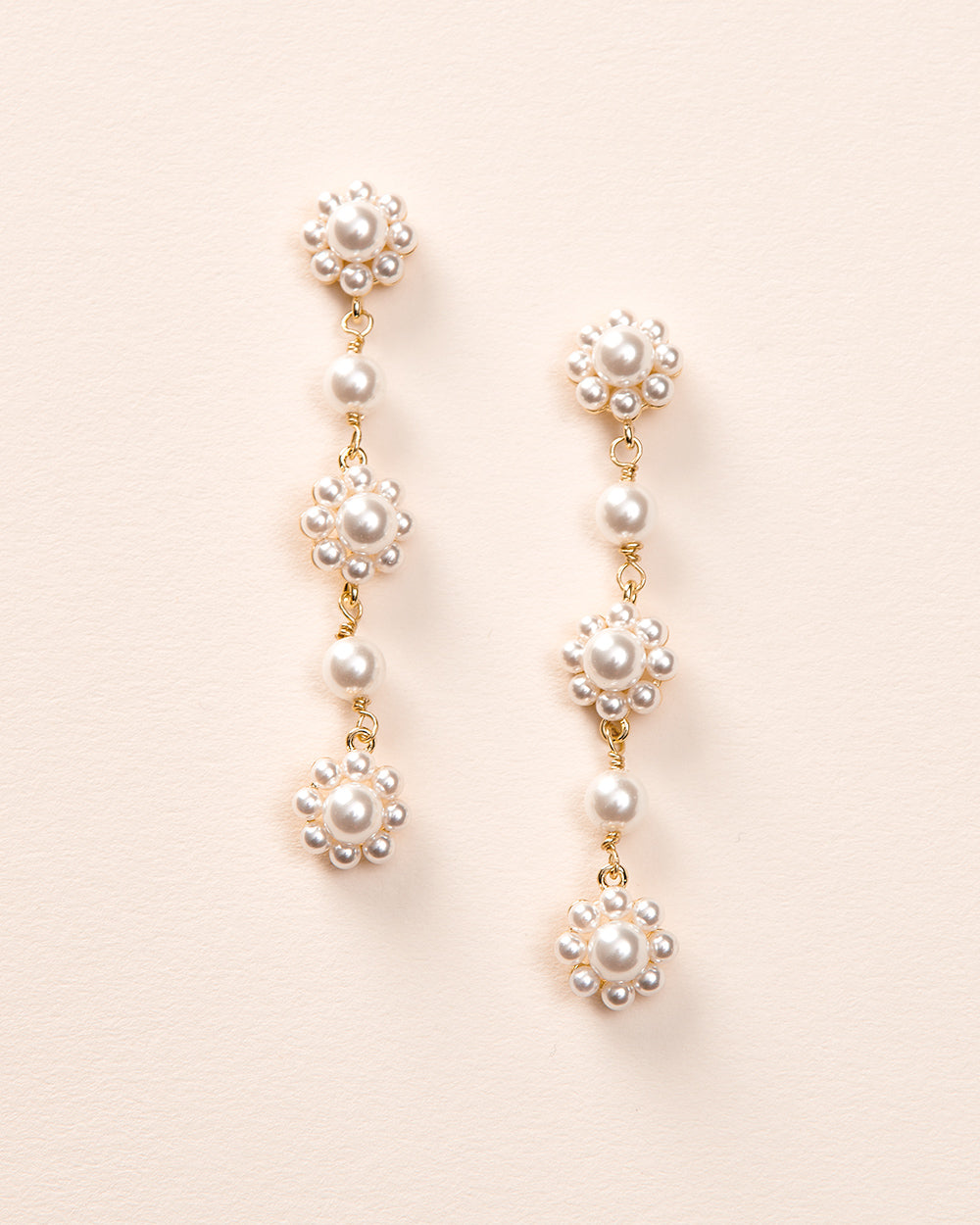 Daria gold pearl dangle earrings with three floral pearl clusters linked by single pearls