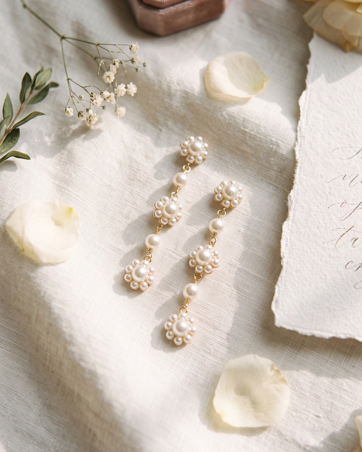 Daria floral pearl earrings on ivory linen with rose petals and baby's breath