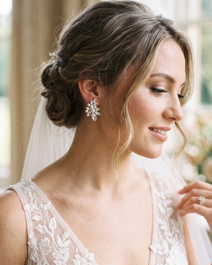 Bride with a low updo and veil wearing the Gwyneth pearl and rhinestone earrings