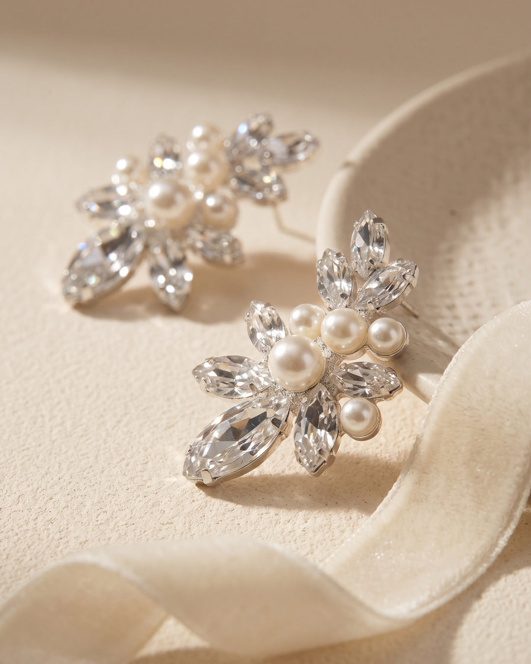 Pair of Gwyneth bridal earrings showing the pearl cluster set among marquise rhinestones