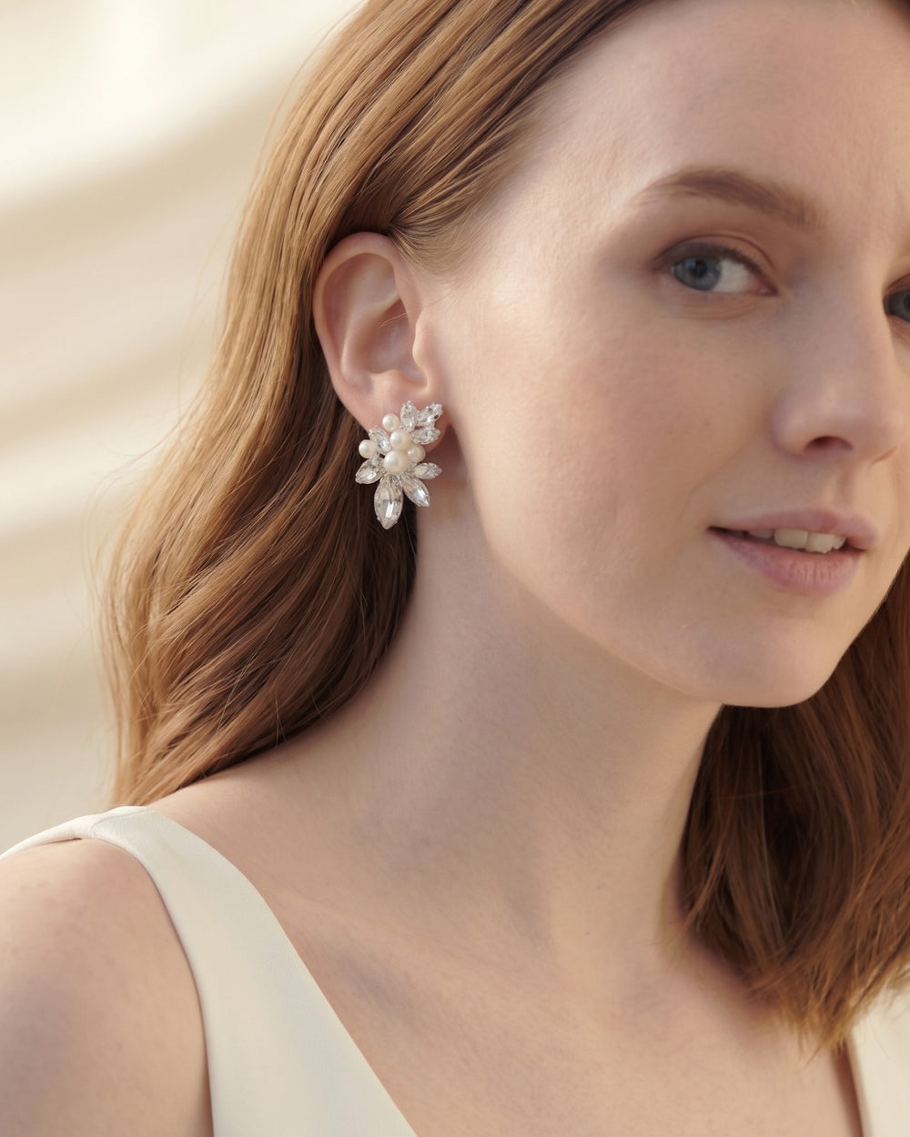 Close look at a Gwyneth wedding earring on the ear, pearls clustered among marquise rhinestones