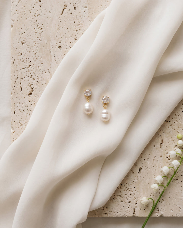 Isabella pearl earrings on ivory silk and travertine with lily of the valley