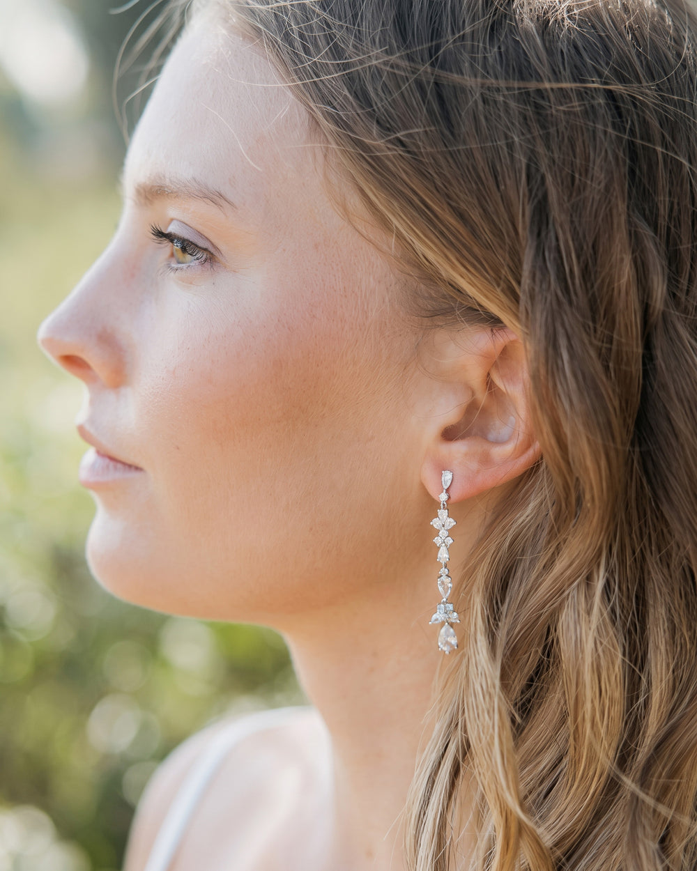 Profile of a bride wearing the Landri CZ drop earrings with long soft waves