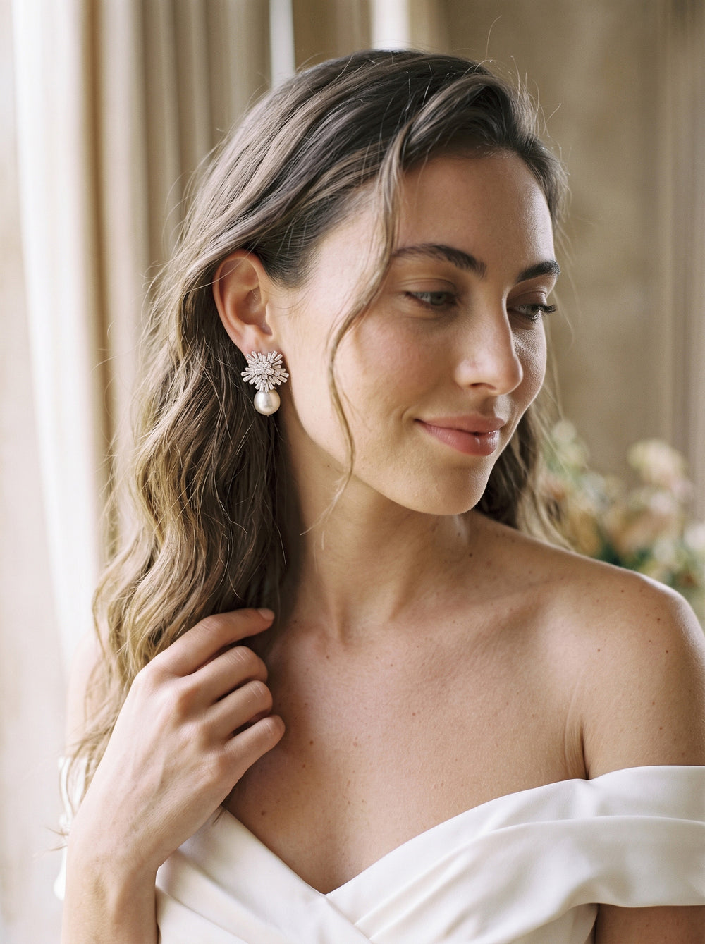 Bride with long waves in an off-shoulder gown wearing Matilda pearl and cubic zirconia earrings