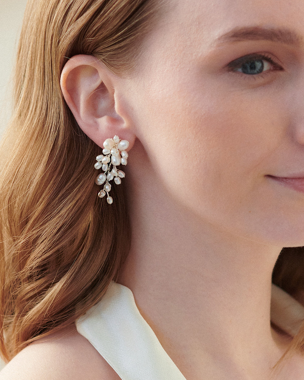 Close look at a freshwater pearl cluster earring on the ear, showing each pearl's natural shape