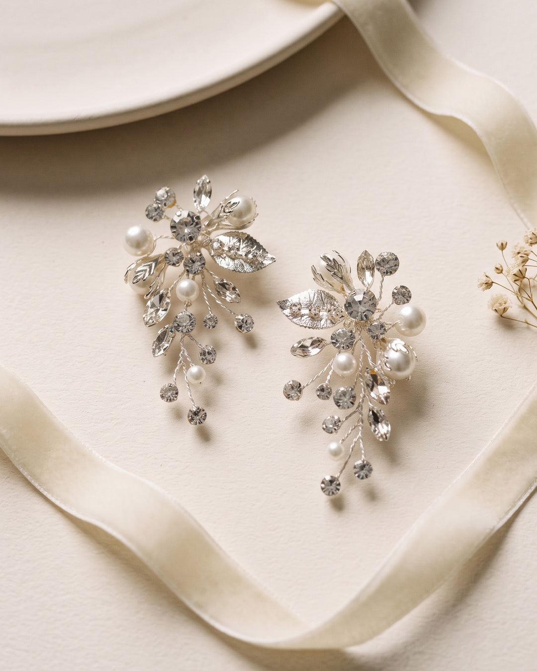 Pair of Alessia bridal earrings showing hand-wired light ivory pearls among marquise crystals