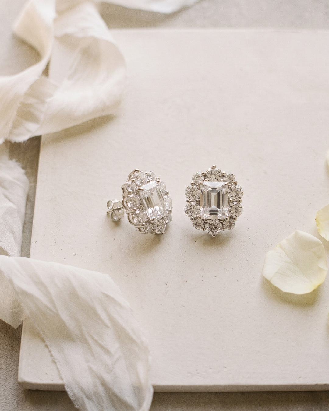 Sienna wedding studs on a cream board with silk ribbon and a single petal