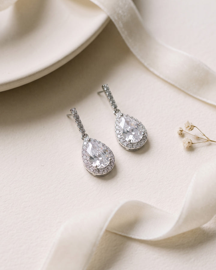 Pair of Harper earrings showing the slim CZ bar above each sparkling teardrop