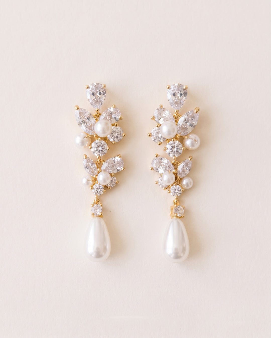 Gold version of the Melina earrings with cubic zirconia clusters and a light ivory teardrop pearl