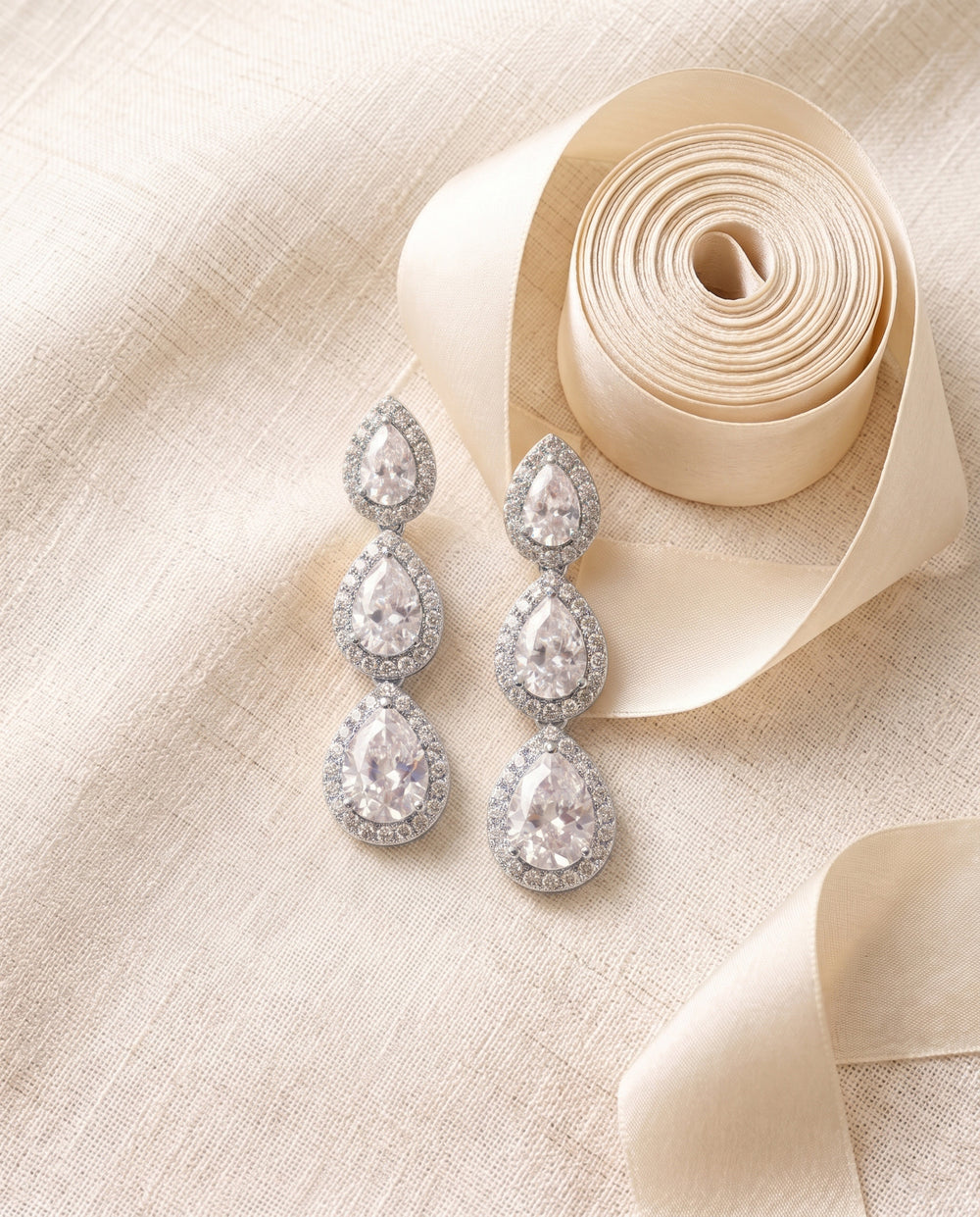 Close view of the Willa wedding earrings showing three graduated pear drops, each in a halo