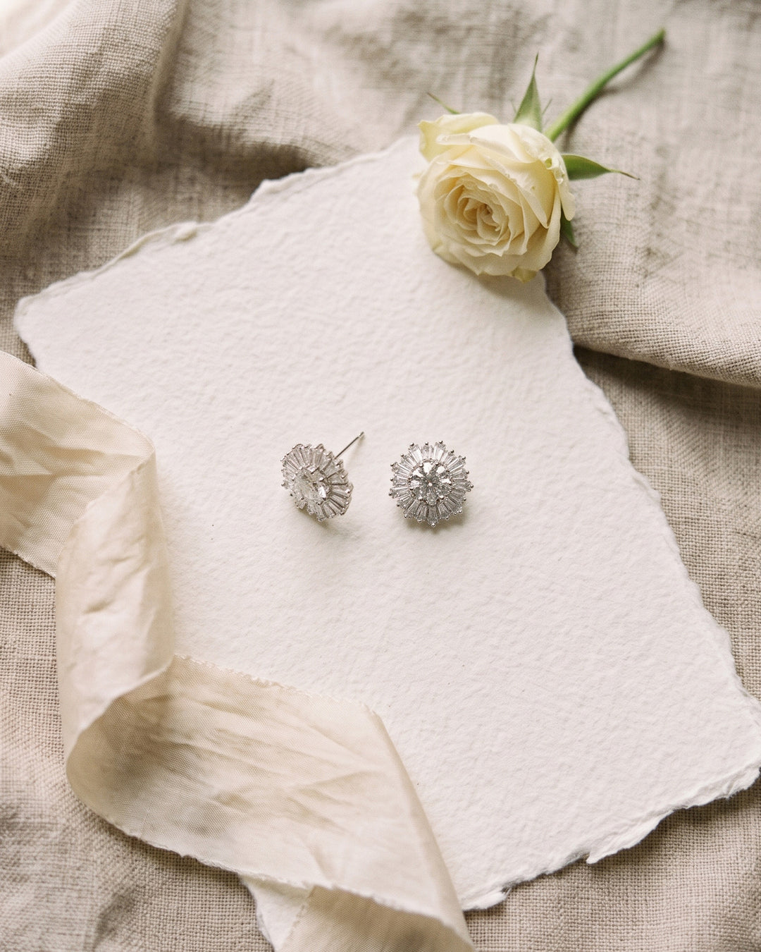 Shivani wedding studs on handmade paper with a cream rose and linen