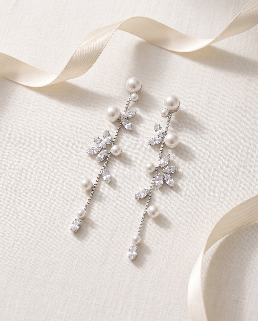 Full length of the Katrina bridal earrings, pearl studs leading into marquise cubic zirconia clusters on a slim chain