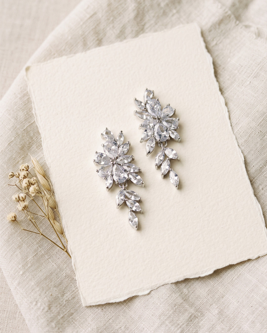 Vivian earrings on deckle-edge paper showing the CZ flower and cascading marquise leaves