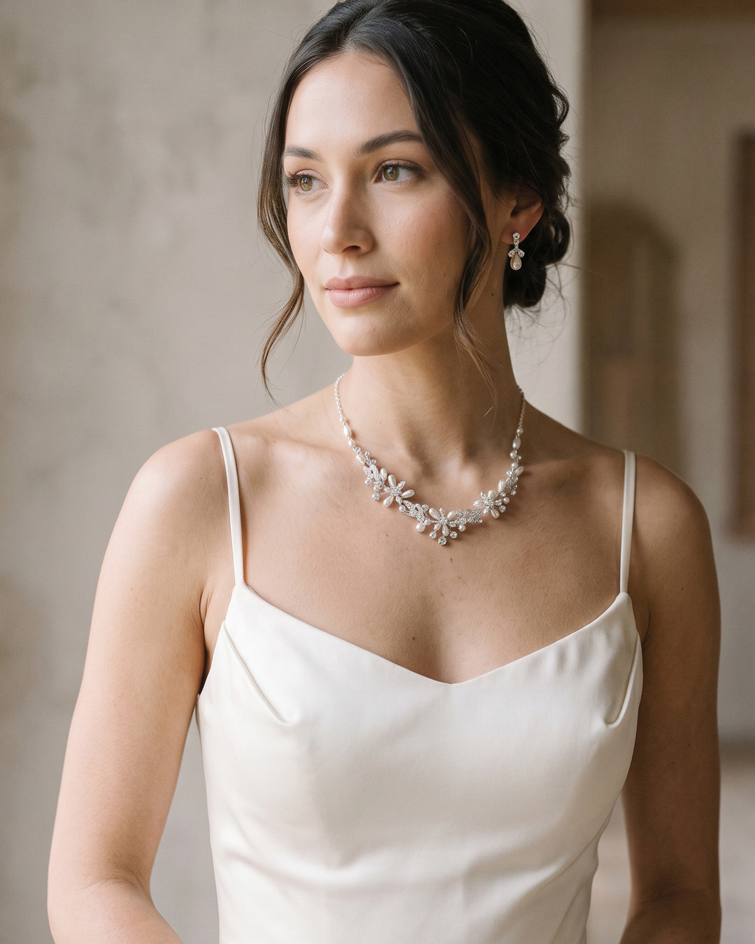 Bride in a satin slip dress wearing the Delicate Pearl wedding necklace and earrings