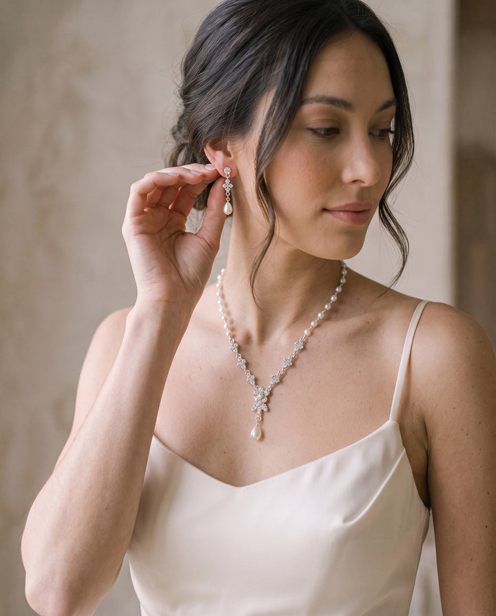Bride touching her Primrose pearl drop earring, matching necklace at her neckline