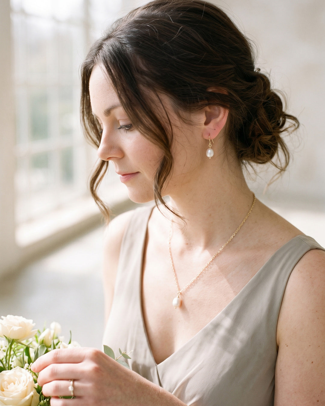 Bridesmaid in a soft greige dress wearing the Simple Pearl pendant necklace and earrings