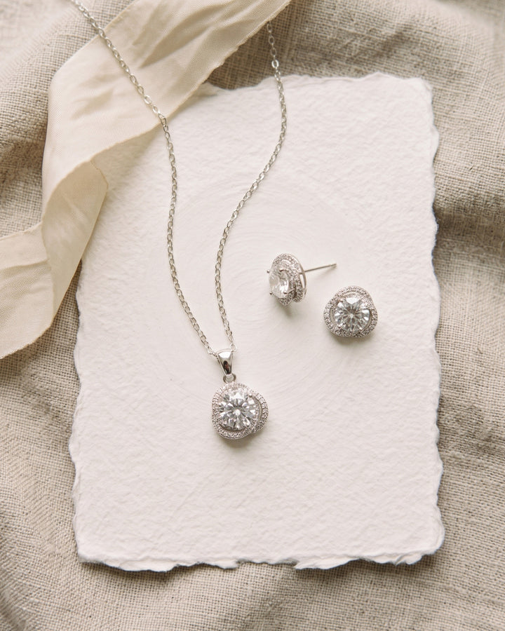 Teagan halo pendant necklace and stud earrings on handmade paper with ivory ribbon