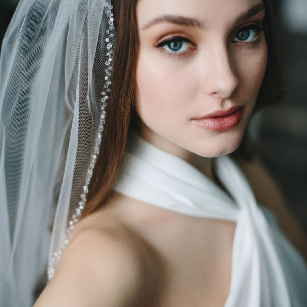 bride wearing crystal edge ivory illusion tulle wedding veil on her wedding day