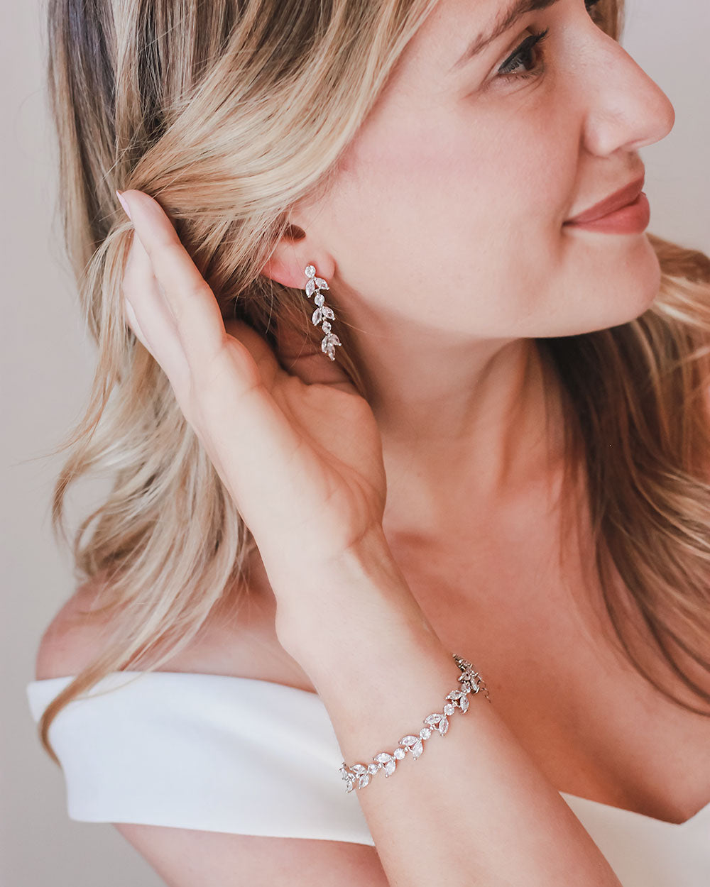 Bride in an off-shoulder gown wearing the Sydney floral wedding earrings and matching bracelet