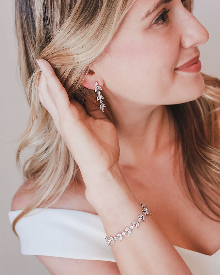 Bride in an off-shoulder gown wearing the Sydney floral wedding earrings and matching bracelet