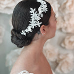 Bride wearing flower hair piece with flowers, pearls and rhinestones