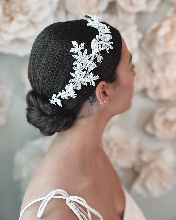 Bride wearing flower hair piece with flowers, pearls and rhinestones