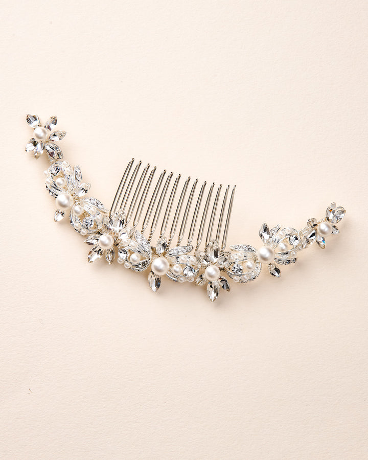 Silver hair comb with pearls and crystals on a beige background