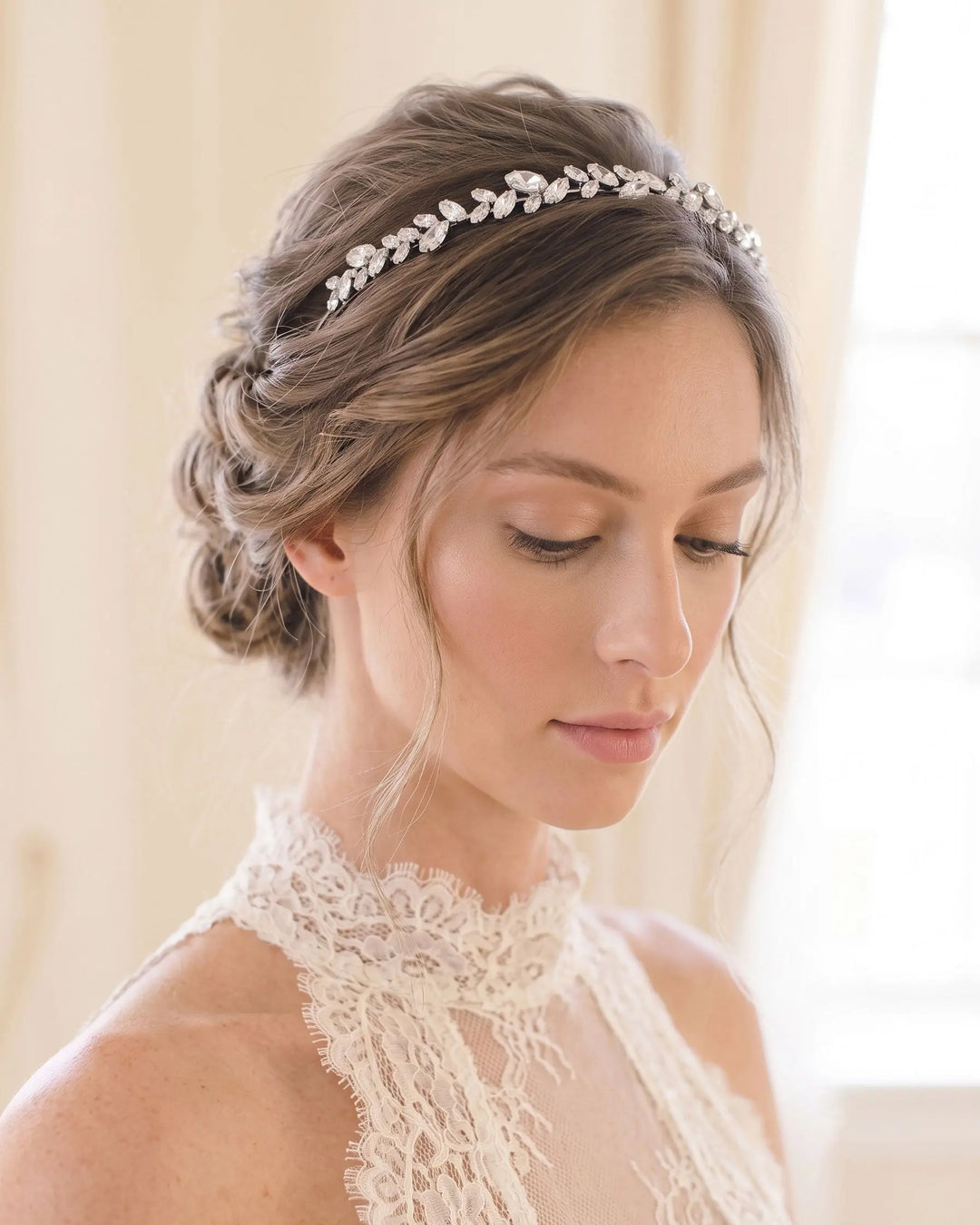 Priya slim silver bridal headband with rhinestone leaves worn across the crown with a soft low updo and lace gown