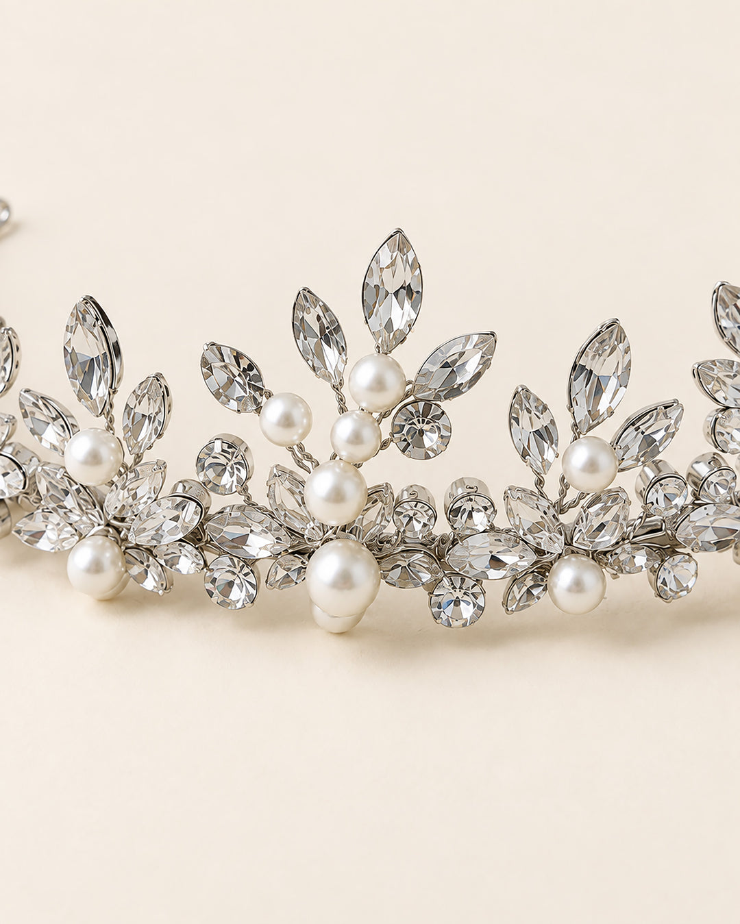 Close-up of marquise rhinestone leaves and ivory pearls at the center peak of the Amalie wedding tiara