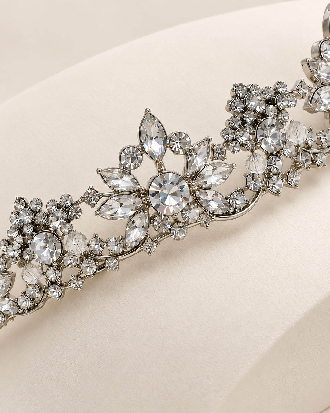 Close-up of marquise and round rhinestone blossom clusters on a silver wedding tiara