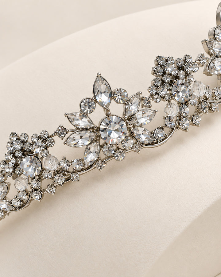 Close-up of marquise and round rhinestone blossom clusters on a silver wedding tiara